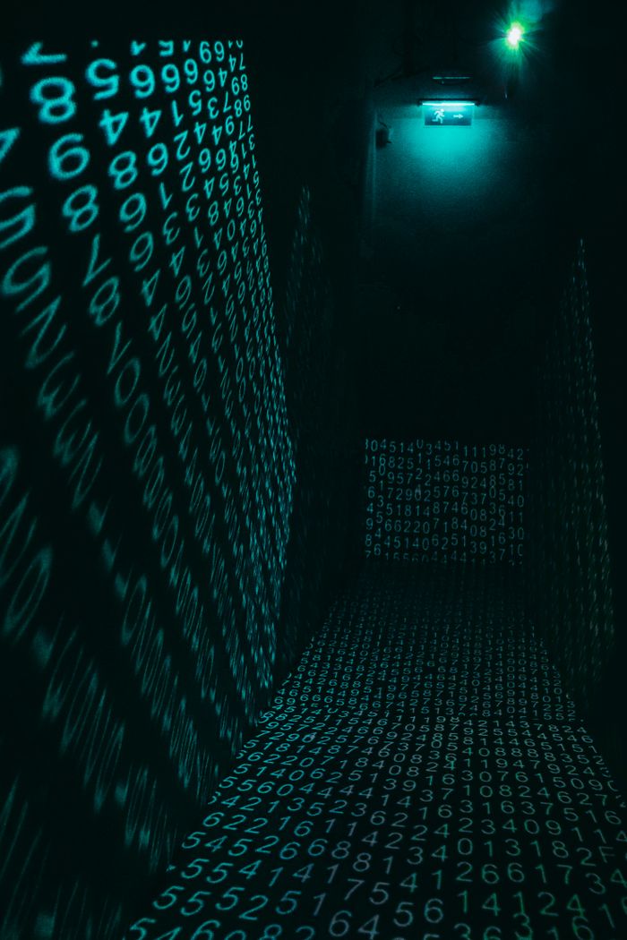 A dark hallway illuminated with neon digital number projections, creating a cyberpunk ambiance.